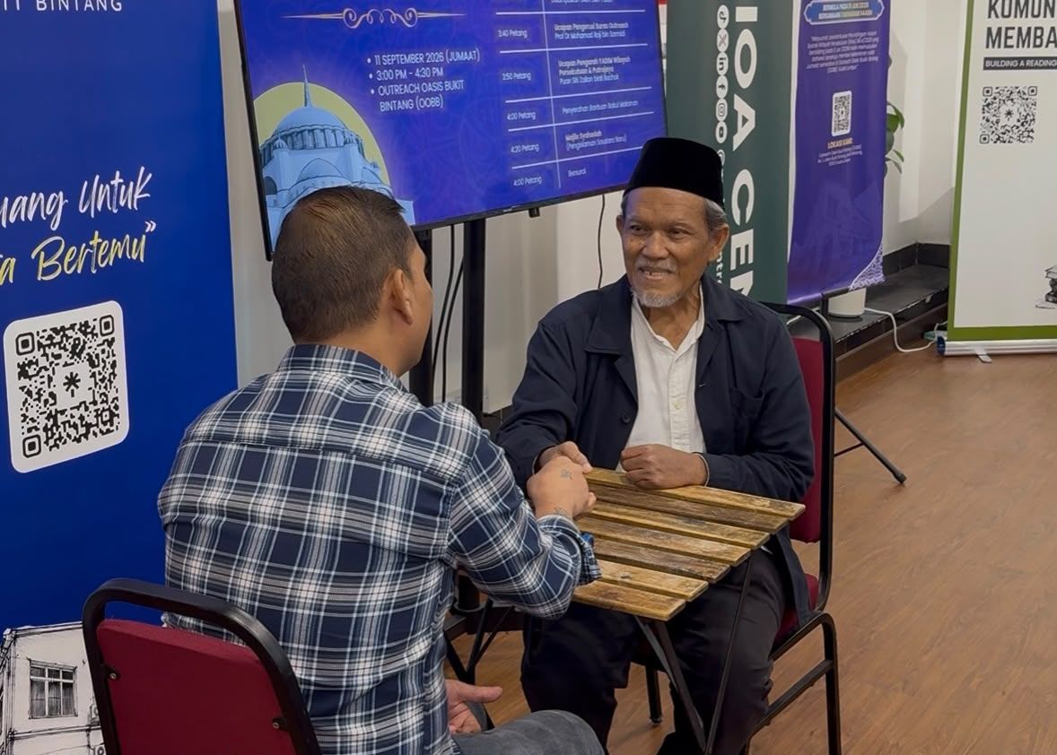 Saudara baharu berjabat tangan dengan pendakwah selepas majlis syahadah di Outreach Oasis Bukit Bintang