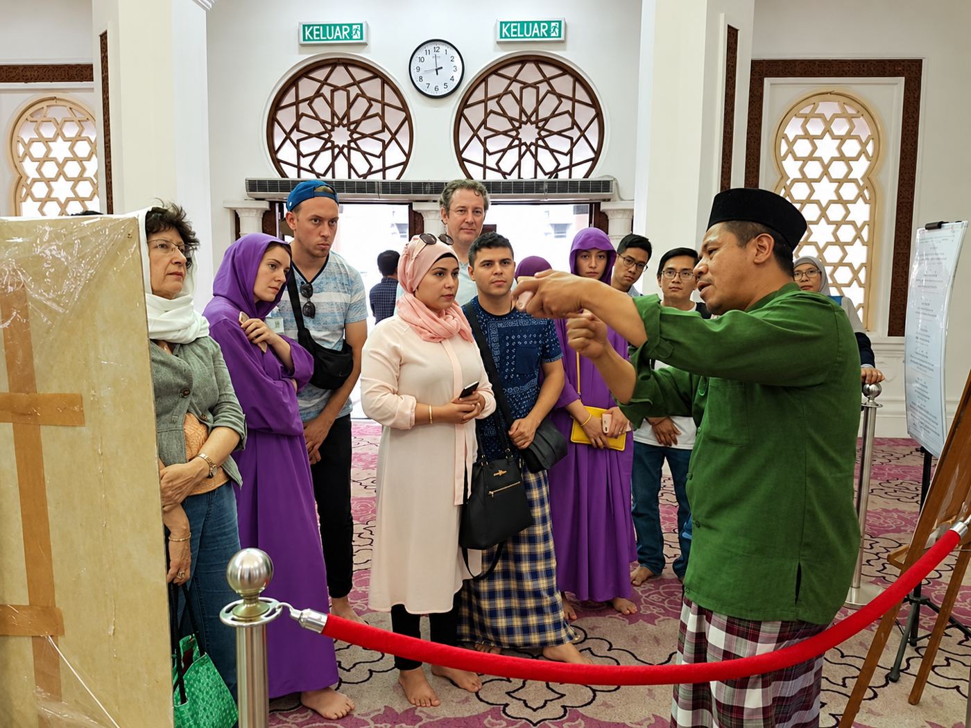 Sukarelawan menerangkan kepada pelancong asing di dalam masjid